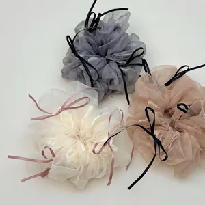 Trois chouchous élégants en organza avec rubans délicats sur fond blanc immaculé