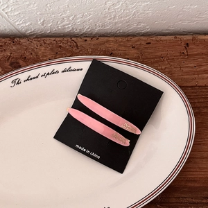 Detail of pink acetate hair clips with gold Barrette La France lettering on a black card