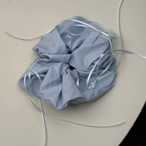 Detailed macro view of a light blue ribbon scrunchie with soft breathable cotton fabric