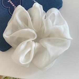Close-up of elegant pearl white mesh organza scrunchie with soft fabric texture and luster