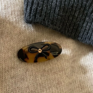 French tortoiseshell oval hair clip with black bow and sparkling orange rhinestone