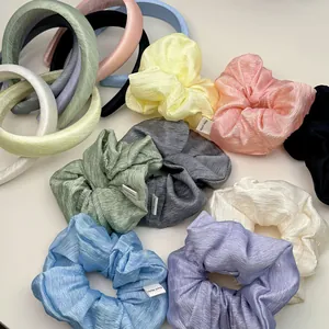 Close-up of handmade textured macaron fabric headbands and scrunchies in various colors