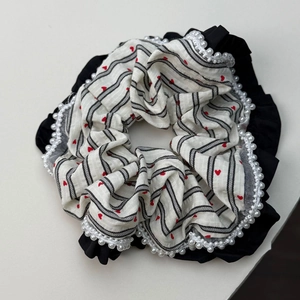 Detail of lace hair scrunchie with red hearts, black stripes and faux pearl trim