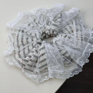Detail of red heart patterned stripes and white lace edges on a sweet ballet hair scrunchie