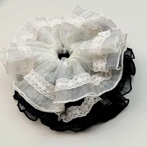 Lace-edged ruffled scrunchies in black and white sheer fabric for elegant hair styling