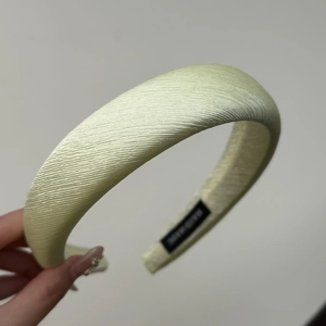 Detail of pistachio green textured fabric headband with handmade label and thick padding
