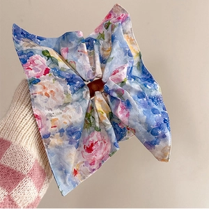 Chic floral scrunchie with oversized bow in blue and pink pattern for elegant hair styling
