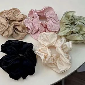 Five assorted satin scrunchies in cream, pink, green, and black for elegant ponytails