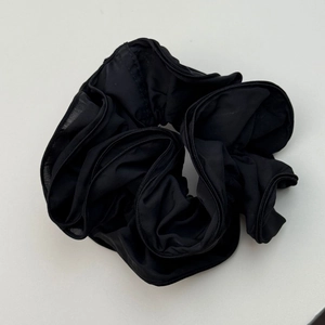 Close-up of black oversized scrunchie with layered chiffon ruffles for elegant hair styling