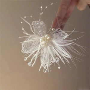 Détail macro d'une pince à cheveux papillon en dentelle blanche avec perles et plumes