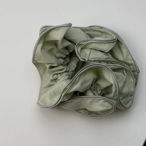 Detailed view of mint green ruffled scrunchie with soft fabric texture and stitching