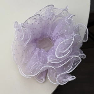 Detail of light purple mesh scrunchie featuring white polka dots and ruffled edges texture