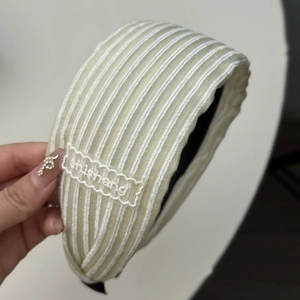 Vue détaillée du serre-tête en tissu rayé vert clair avec étiquette brodée shishang