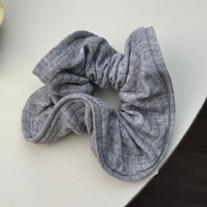 Gros plan sur la texture en tricot rayé gris d'un chouchou souple surdimensionné