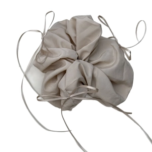 Beige cotton drawstring jewelry pouch with ribbon bow for elegant gift packaging