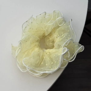 Detail of light yellow mesh scrunchie with 3D polka dots and white scalloped embroidery