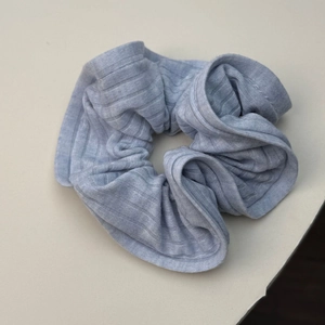 Texture détaillée du chouchou en maille côtelée bleu clair avec bords élastiques festonnés