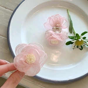 Barrette à cheveux fleur de camélia en organza rose avec des couches de maille légères