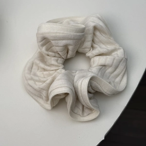 Gros plan sur un chouchou en maille côtelée blanc crème avec texture plissée