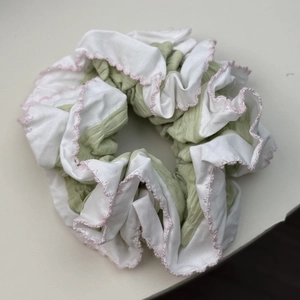 Détail d'un chouchou froissé avec panneaux vert et blanc et coutures roses ondulées