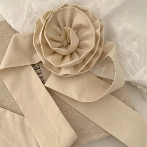 Détail du chouchou rose en tissu beige surdimensionné avec de longs rubans élégants