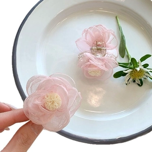 Barrettes à cheveux élégantes avec fleurs de camélia en organza rose sur un plateau