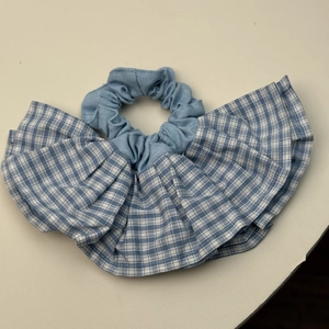 Gros plan d'un chouchou à carreaux bleus et blancs avec des volants en tissu de coton