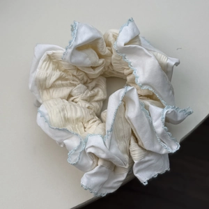 Détail d'un chouchou large avec dentelle bleue et tissus plissés beige et blanc doux