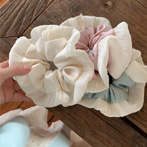 Chouchous en satin à volants rose et pastel pour coiffures de ballet sur fond de bois