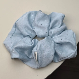 Light blue satin hair scrunchie with sparkling silver rhinestones and woven label tag