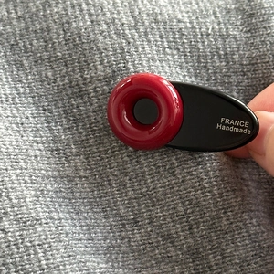 Détail d'une pince à cheveux fleur faite main avec texte 'FRANCE Handmade' sur résine