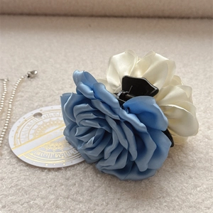 Pince à cheveux élégante avec roses en soie bleue et crème sur fond en peluche douce
