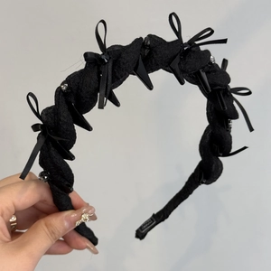 Dettaglio del cerchietto in rete nera con strass, fiocco e borchie in stile punk
