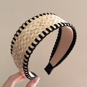 Détail d'un serre-tête en paille tressée avec coutures noires et doublure rose