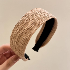 Detailed close-up of woven raffia texture and black non-slip lining on wide headband