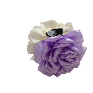 Pince à cheveux rose en soie violette et crème pour chignons sur fond blanc pur