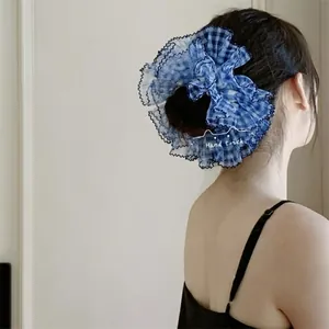 Chouchou à carreaux bleu et blanc avec bords ondulés noirs porté sur un chignon élégant