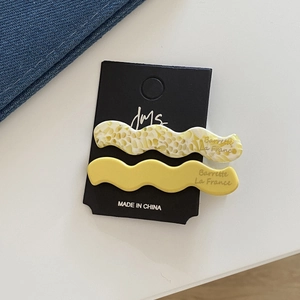 Détail de barrettes à cheveux ondulées en acétate avec motif en nid d'abeille sur carte