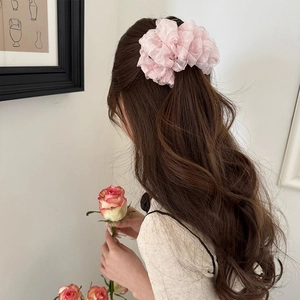 Detail of soft pink organza scrunchie on long hair with a romantic aesthetic