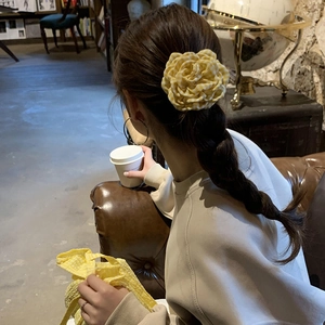 Elegant yellow gingham fabric flower hair claw clip displayed on a ponytail for women