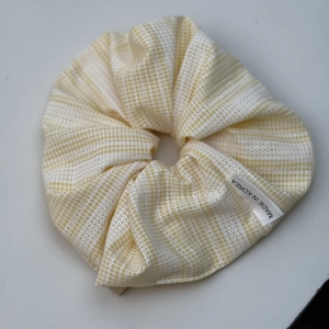 Détail du chouchou à carreaux jaunes avec étiquette Made in Korea et texture du tissu