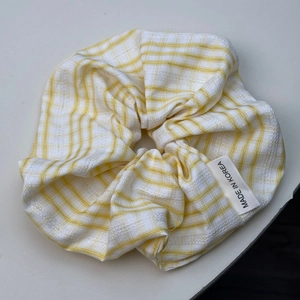 Gros plan détaillé du chouchou à carreaux jaunes et blancs avec broderie en dentelle