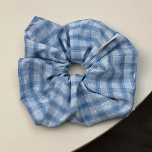 Macro view of blue and white checkered scrunchie fabric texture with a side label