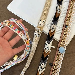 Bohemian braided belt with seashells and tassels on a rustic vintage background