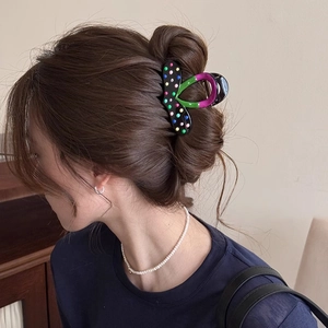 Pince à cheveux noire à pois colorés avec accents néon violets sur cheveux
