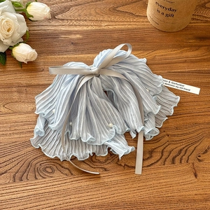 Detail of light blue pleated mesh bow hair claw clip with white pearls and grey ribbon