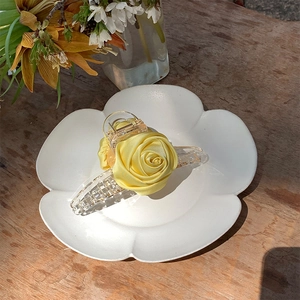 Detail of handmade cream silk rose hair claw clip with transparent acrylic base