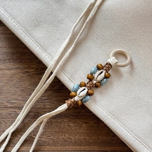 Close-up of bohemian woven cord with natural shells and polished wooden beads texture