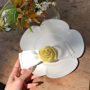 Detail of handmade yellow 3D fabric rose and white satin bow hair clip accessory