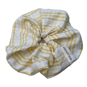 Chouchou à carreaux jaune et blanc avec texture dentelle et étiquette sur fond blanc